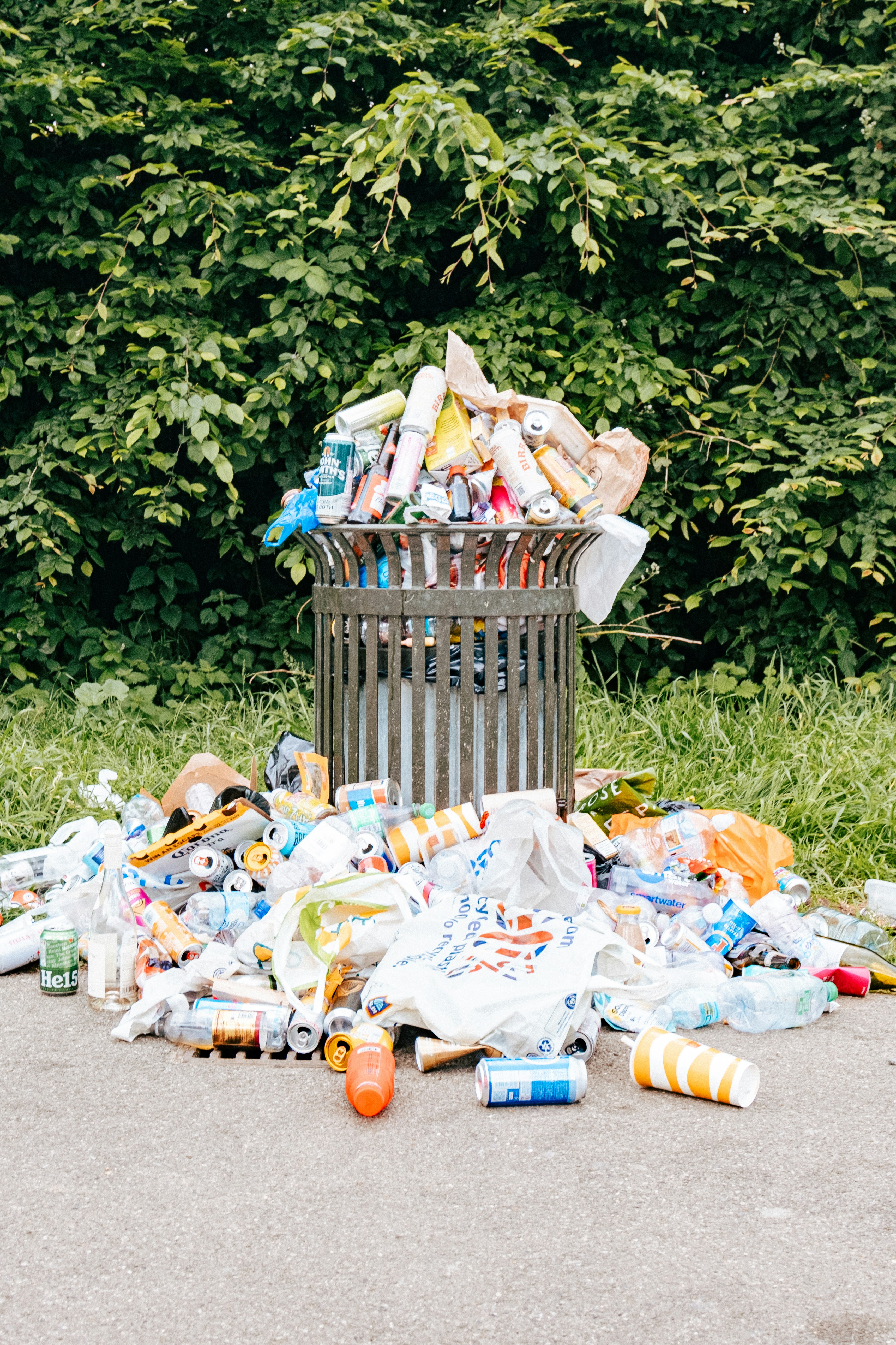 An overflowing public waste bin — recyclable materials that could have been recovered